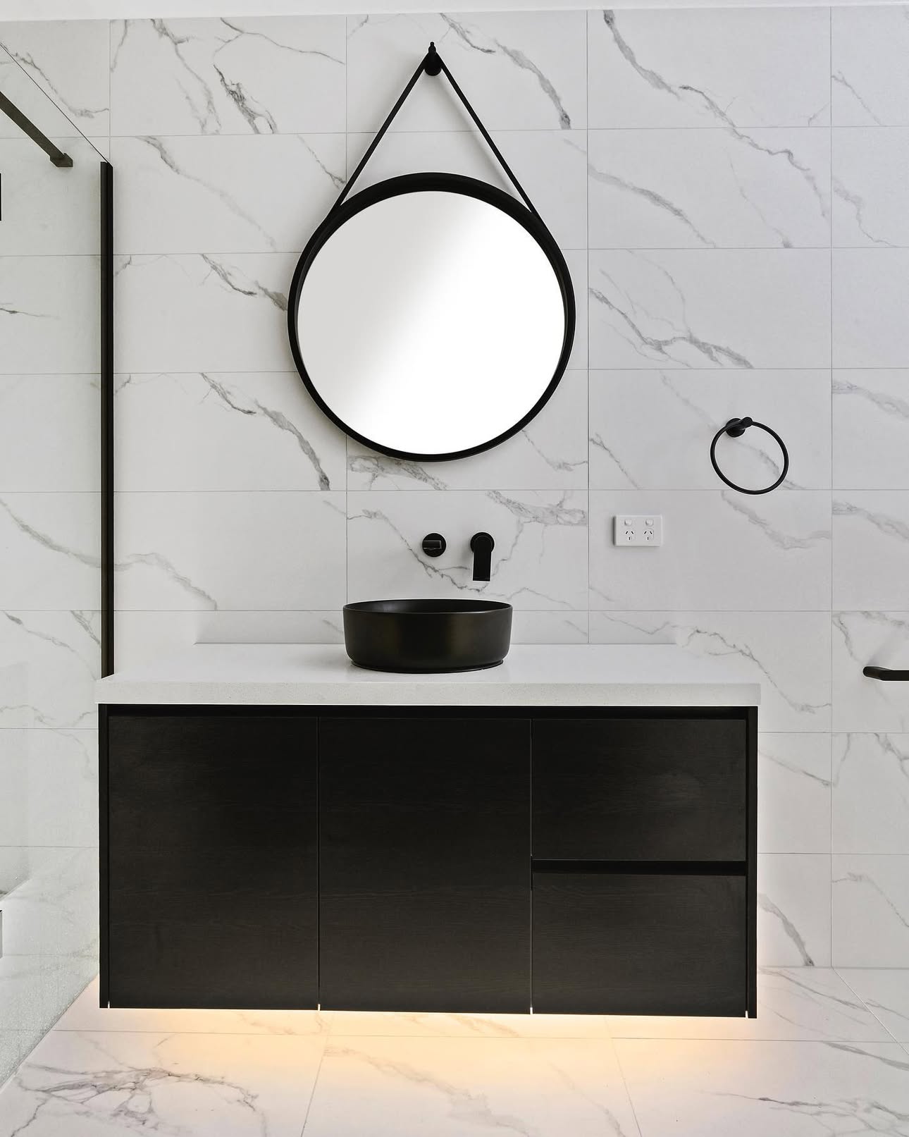 Black linear pendant over a white kitchen