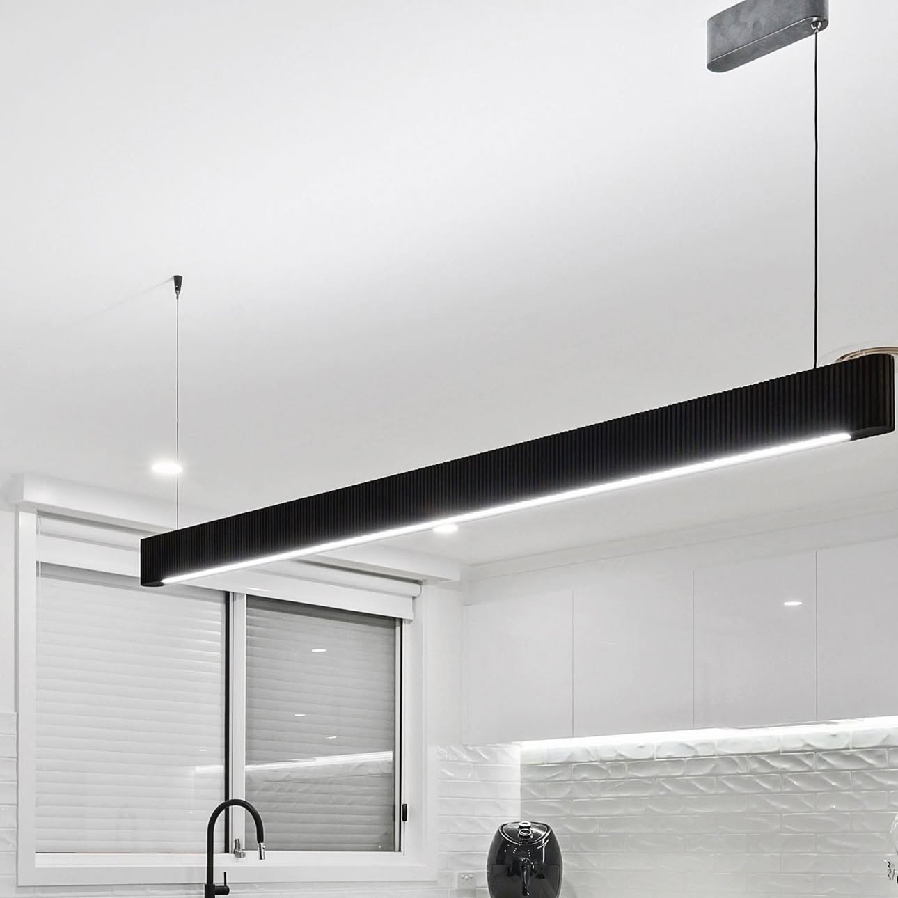 Kitchen with black linear pendant feature